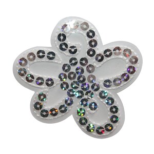 Può includere: Un'applicazione di fiore in tessuto bianco con paillettes iridescenti. Il fiore ha cinque petali e misura circa 5 cm di diametro.