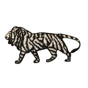 May include: Black and white embroidered iron-on patch of a lion with a striped pattern.