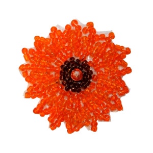 Può includere: Applique di fiore in perline arancioni e marroni. Il fiore è fatto di piccole perline rotonde e ha un cerchio centrale di perline marroni.