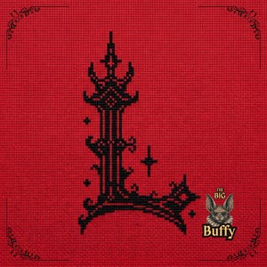 May include: A black cross-stitch letter L embroidered on a red fabric background. The letter features ornate, gothic-inspired details and small star accents. In the bottom right corner, a small bat illustration appears above the text THE BIG Buffy.