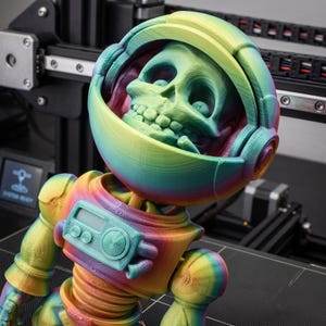 May include: A 3D-printed rainbow-colored astronaut figurine featuring a skull head inside a helmet, a chest control panel with dials, and articulated limbs. The figure displays visible layer lines from the printing process and a gradient finish.