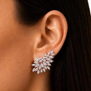 May include: A gold-toned ear climber earring featuring a cluster of marquise-cut clear stones arranged in a leaf-like pattern that follows the curve of the earlobe. The earring is crafted with multiple faceted white stones set in a metallic frame.
