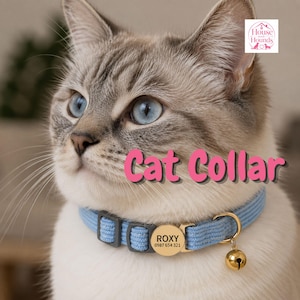 Può includere: Un collare per gatti in tessuto azzurro con una targhetta identificativa rotonda in metallo dorato incisa con il nome ROXY e il numero 0987 654 321, un piccolo campanello dorato e fibbie di regolazione in plastica grigio scuro.