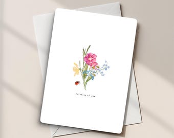Cartolina di auguri con bouquet di fiori selvatici ad acquerello: illustrazione floreale con coccinella per esprimere condoglianze o augurare pronta guarigione.