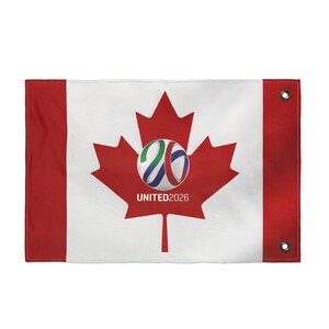Può includere: Una bandiera rettangolare con il design della bandiera canadese, con una grande foglia d'acero rossa al centro. Una grafica di pallone da calcio con la scritta "UNITED2026" è sovrapposta alla foglia d'acero. La bandiera ha bordi rossi e occhielli.
