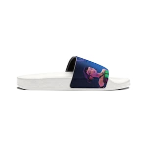 Può includere: Sandalo a fascia bianco con un'illustrazione colorata di una donna con i capelli scuri. Il sandalo ha un cinturino nero e una suola bianca. L'opera raffigura una donna su uno sfondo blu scuro.