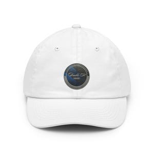 Può includere: Cappellino da baseball bianco con visiera curva. Il cappellino presenta un emblema circolare con il testo "Elegante Stile Italiano" e "Double S!" in un design blu e argento. Il cappellino è realizzato in materiale morbido.