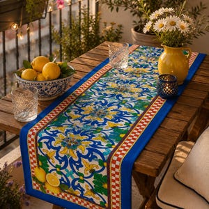 Puede incluir: Una mesa de madera preparada para cenar en un balcón. Un camino de mesa azul y blanco estampado con un borde a cuadros rojo y blanco recorre el centro. Un cuenco con limones, una jarra amarilla con margaritas y dos vasos están sobre la mesa.