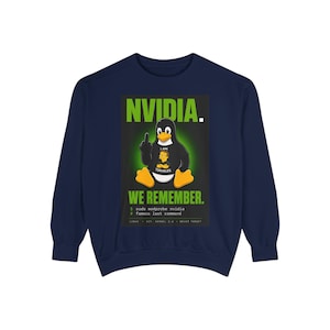 Op de afbeelding: Een marineblauw sweatshirt met ronde hals en een afbeelding van een pinguïn die een handgebaar maakt. De tekst luidt NVIDIA. WE REMEMBER. I AM TORVALDS, met extra terminal-stijl tekst: $ sudo modprobe nvidia # famous last command.