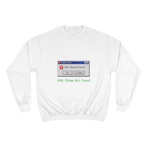 Könnte beinhalten: Weißes Sweatshirt mit einer Grafik einer Systemwarnung. Die Warnung lautet "404: Sleep Not Found" mit den Schaltflächen "OK" und "Try Again". Der Text "404: Sleep Not Found" ist ebenfalls darunter gedruckt.