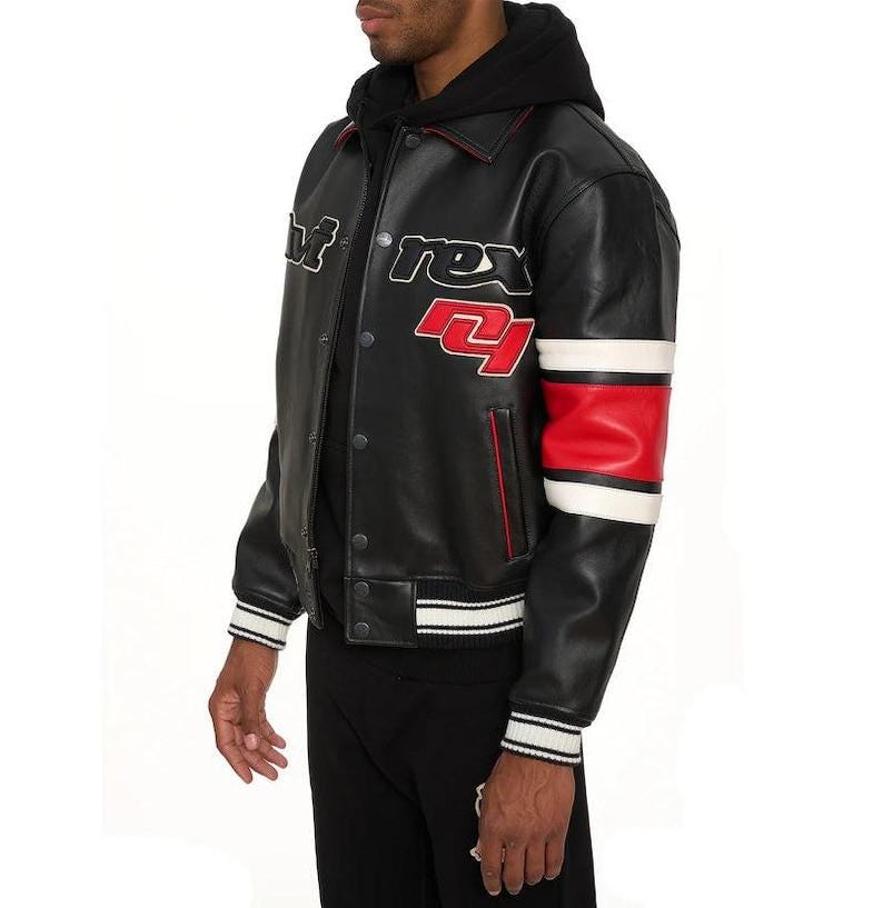 May include: Black leather jacket with white and red accents. The jacket features the text "rex 21" on the chest and a red and white stripe on the sleeve. The jacket has a button-up front and a ribbed hem and cuffs.