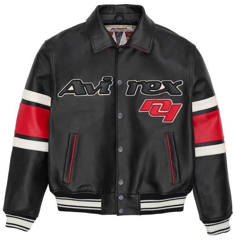 May include: Black leather jacket with the word "Avi rex" in white and red lettering. The jacket has red and white stripes on the sleeves and a ribbed hem and cuffs. The jacket has a button-up front and two front pockets.