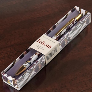 May include: A Bruno Visconti Felicita metal ballpoint pen with a floral pattern in shades of purple, brown, and white. The pen features gold-colored metal accents and is housed in a matching floral-patterned box with a paper band displaying the text.