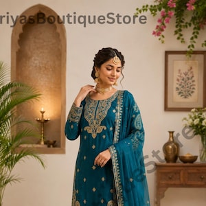 Könnte beinhalten: Türkisfarbenes, besticktes Salwar-Kameez-Set. Die langärmlige Tunika und die passende Hose sind mit goldfarbenen Stickereien am Ausschnitt, an den Ärmeln und am Saum versehen. Ein durchsichtiges, türkisfarbenes Dupatta vervollständigt das Ensemble. Der Text "PriyasBoutiqueStore" ist sichtbar.