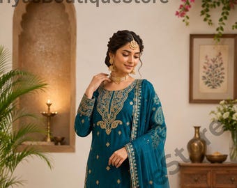 Puede incluir: Conjunto salwar kameez bordado de color turquesa. La túnica de manga larga y los pantalones a juego presentan bordados dorados a lo largo del escote, las mangas y el dobladillo. Un dupatta de gasa turquesa completa el conjunto. El texto "PriyasBoutiqueStore" es visible.