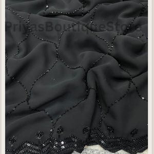May include: A black fabric textile featuring a delicate grid pattern formed by small, dark sequins. The bottom edge is finished with a wide, scalloped border densely embellished with matching black sequins. The text PriyasBoutiqueStore is visible.