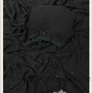 May include: A black fabric garment featuring a delicate grid pattern formed by small black beads and scattered sequins. The material has a soft, draped texture with a decorative beaded border along the edge. The text PriyasBoutiqueStore is visible.