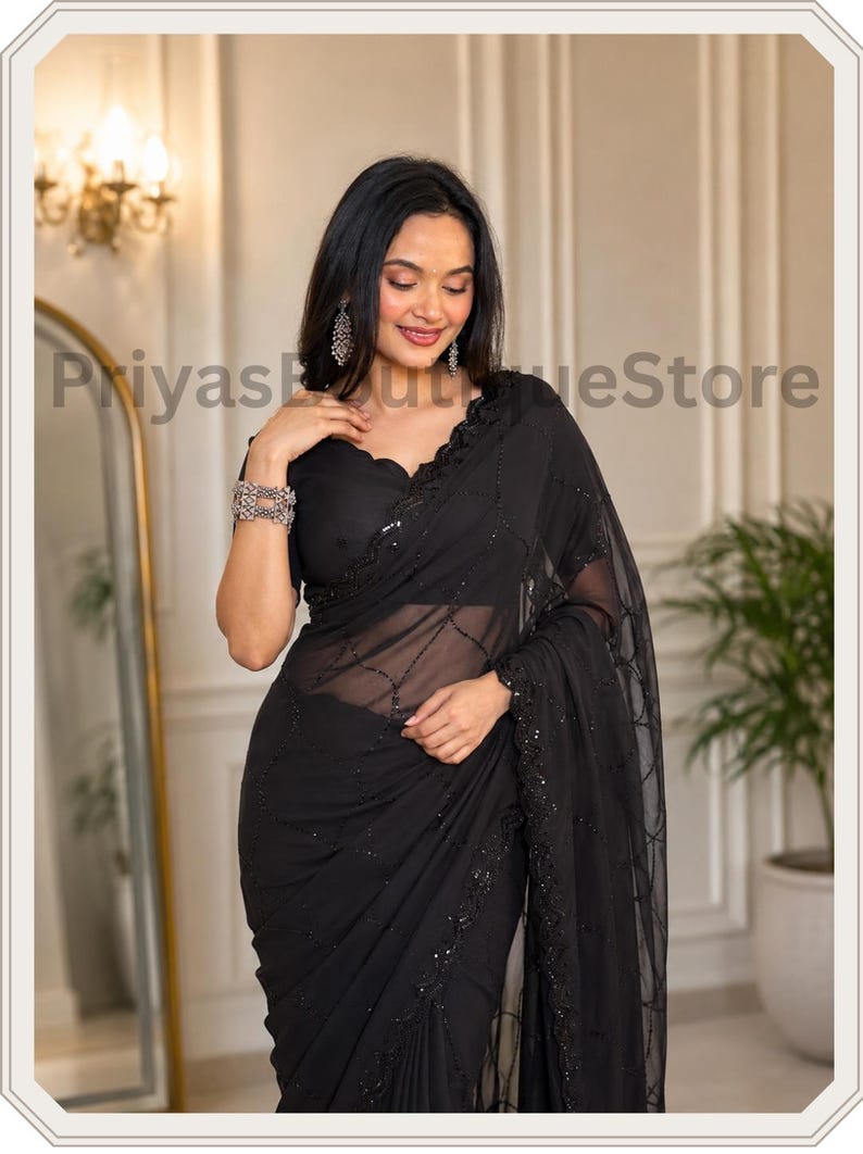 May include: A black saree featuring a sheer fabric with intricate black sequin embroidery in a geometric pattern. The garment includes a scalloped neckline on the blouse and a matching black border adorned with detailed sequin work throughout.