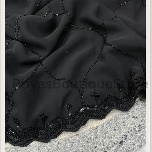 May include: A black fabric featuring a delicate scalloped edge adorned with intricate black beadwork and sequins. The material displays a repeating lattice pattern created by fine black beads, with small floral-like clusters at each intersection.