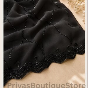 May include: A black fabric textile featuring a delicate diamond-shaped grid pattern embellished with small black sequins. The edge is finished with a decorative zigzag border adorned with intricate beadwork. The text PriyasBoutiqueStore is visible.