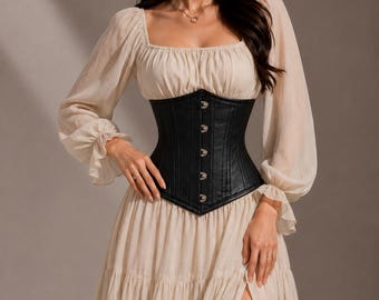 May include: A beige long-sleeved dress with a square neckline and ruffled cuffs, paired with a black structured corset featuring a front busk closure with silver-toned metal clasps. The dress has a tiered skirt with a high side slit.