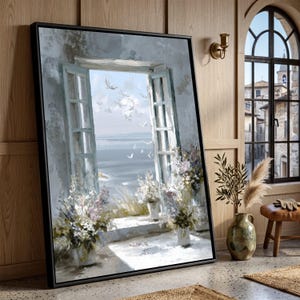 May include: A framed rectangular wall art piece depicting an open window overlooking a calm sea with flying white birds. The scene features light blue shutters, stone ledges, and potted floral arrangements in shades of white, blue, and green.