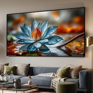May include: A rectangular wall art print featuring a large, vibrant blue lotus flower with a bright orange centre. The petals are covered in clear water droplets, set against a blurred background of autumn-toned orange and brown leaves.