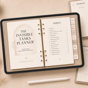 May include: A digital planner titled The Invisible Tasks Planner displayed on a tablet with a gold ring binder mechanism. The screen shows an index page with numbered sections and tabs. A white stylus rests below the tablet, with additional planner pages visible nearby.
