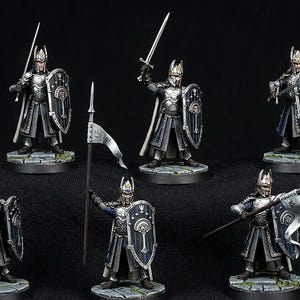 May include: A set of six miniature fantasy warrior figurines standing on circular stone-textured bases. Each figure wears silver plate armour, a long tunic, and a tall helmet, carrying a dark blue shield with a white tree emblem and a sword or flag.