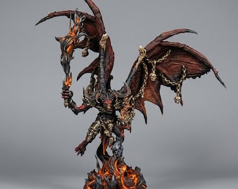 May include: A detailed miniature figurine of a winged demon with dark red skin, large horns, and glowing orange eyes. The figure holds a flaming weapon, is adorned with hanging skull ornaments and chains, and stands atop a base of molten lava.