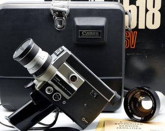 Może przedstawiać: Czarno-srebrna kamera filmowa Super 8 Canon Auto Zoom 518 SV z obiektywem, dodatkową nasadką obiektywu, czarnym futerałem z napisem 518 SV, dekielkiem na obiektyw oraz dokumentem Canon Authorized Service Facilities z wydrukowanym tekstem.