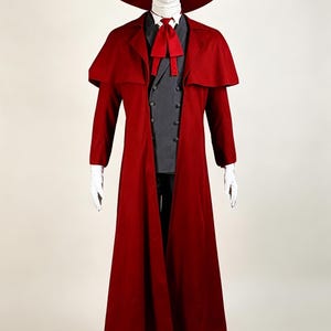May include: A red costume ensemble featuring a wide-brimmed hat, long coat with cape, vest, and tie. The hat has a white band. The coat and tie are a deep red. The vest is gray. White gloves and boots complete the look.