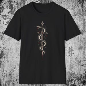 Op de afbeelding: Een zwart T-shirt met korte mouwen en een centrale grafische print van een zilveren zwaard dat is verstrengeld met een kronkelende slang. De slang heeft rode accenten en het gevest van het zwaard is versierd met een rode edelsteen.