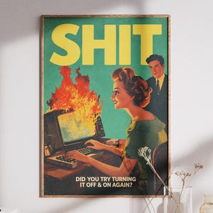 Könnte beinhalten: Ein rechteckiges Wandplakat mit einer Illustration im Vintage-Stil, die eine Person an einem brennenden Computer zeigt. Der Text SHIT erscheint in großen gelben Buchstaben oben, mit DID YOU TRY TURNING IT OFF & ON AGAIN? darunter.