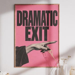 May include: A rectangular wall art print featuring a vibrant pink background with the bold black text DRAMATIC EXIT at the top. Below the text, a black and white image shows a hand with dark fingernails pointing toward the right side.