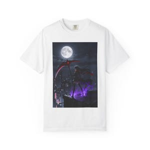 May include: A white short-sleeved t-shirt featuring a graphic print of a figure standing on a rooftop at night. The figure holds a large red scythe under a full moon, surrounded by purple flames against a dark city skyline background.
