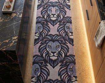 May include: A rectangular runner rug featuring a repeating pattern of stylized lion heads in shades of dark blue, grey, and muted purple. The design consists of multiple lion faces arranged in a symmetrical, interlocking layout across the surface.