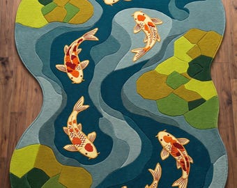 May include: An irregularly shaped area rug featuring a pond scene with five koi fish in shades of orange, white, and black. The background consists of flowing blue and teal water patterns interspersed with patches of lime and olive green lily pads.