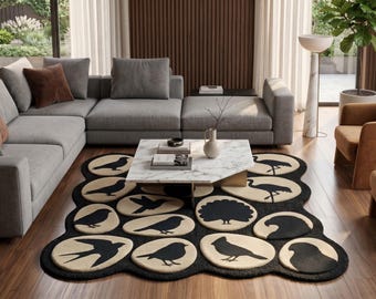 May include: A large area rug featuring a black and cream color palette with a repeating pattern of various bird silhouettes contained within circular and organic shapes, creating a textured surface with a scalloped edge design.