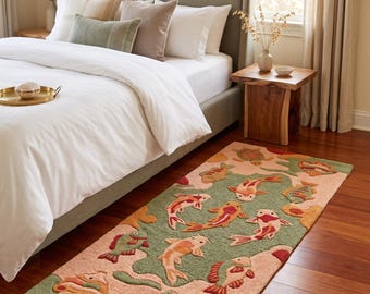 May include: A rectangular area rug featuring a tufted design of koi fish and sea turtles in shades of sage green, peach, orange, and deep red. The rug displays a repeating pattern of aquatic life set against a soft, textured background surface.