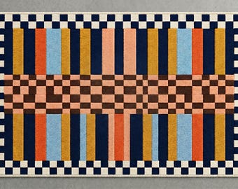 May include: A rectangular area rug featuring a central horizontal band of brown and peach checkered squares. The top and bottom sections display vertical stripes in navy blue, orange, light blue, and gold, framed by a navy and white checkerboard border.