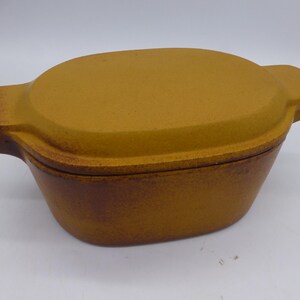 May include: A brown ceramic casserole dish with a lid. The dish has a rustic, textured finish.