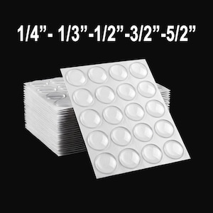 May include: Clear, adhesive bumper pads in various sizes, including 1/4", 1/3", 1/2", 3/2", and 5/2" are shown. The pads are arranged on white sheets, stacked against a black background. The text "1/4"- 1/3"-1/2"-3/2"-5/2"" is displayed at the top.
