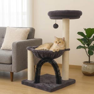 May include: A cat tree featuring a dark gray plush base, a central arch-shaped black grooming brush, and two light-colored sisal-wrapped scratching posts. It includes a dark gray plush hammock and a top platform with a hanging gray ball toy.