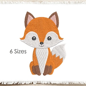 Peut inclure: Un motif de broderie représentant un renard de dessin animé avec une fourrure orange, un poitrail et un visage blancs, des oreilles et des pattes brun foncé, et une queue à bout blanc. Le texte "6 Sizes" est imprimé en noir à gauche.