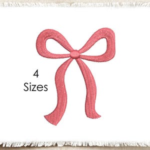 Puede incluir: Un diseño de lazo bordado en color rosa coral centrado sobre un fondo de tela blanca con bordes deshilachados. El texto "4 Sizes" está impreso en negro a la izquierda del lazo. El bordado presenta un patrón de puntadas denso y texturizado.
