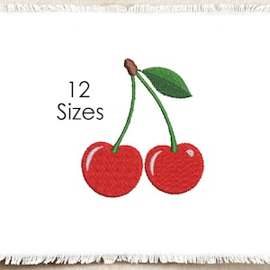 May include: An embroidery design featuring two bright red cherries with green stems and a single green leaf. The text 12 Sizes is printed in black to the left of the cherries. The design is centered on a white fabric square with frayed edges.