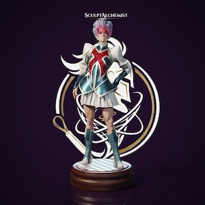 May include: A figurine of a character with grey hair, wearing a white and teal jacket with a red cross design, a white pleated skirt, and teal boots. The figure stands on a circular base. The text SCULPTALCHEMIST is visible at the top.