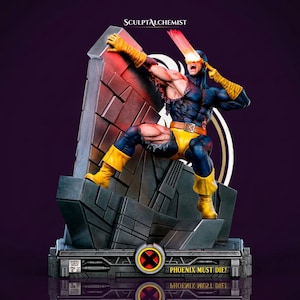 May include: A detailed collectible statue of a comic book character in a blue and yellow suit, firing a red optic blast from their visor while leaning against a dark gray stone wall. The base features the text PHOENIX MUST DIE and an X-Men logo.