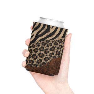 May include: A beverage can cooler featuring a three-part horizontal design. The top section displays a black and tan zebra stripe pattern, the middle section shows a tan and black leopard print, and the bottom section has a textured brown leather pattern.